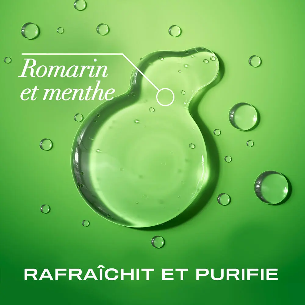 Traînée de shampooing extra fort romarin et menthe OGX® sur un fond vert