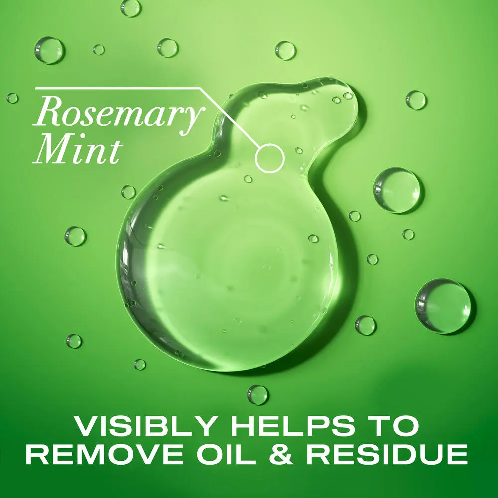 OGX® Rosemary Mint Extra Strength Shampoo product smear on a green background
