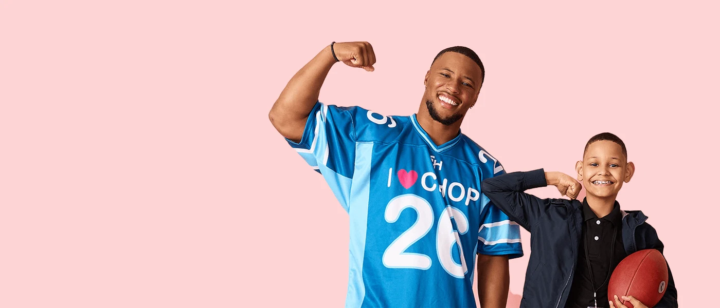 Saquon Barkley and CHOP Patient, Preston, flex towards the camera.