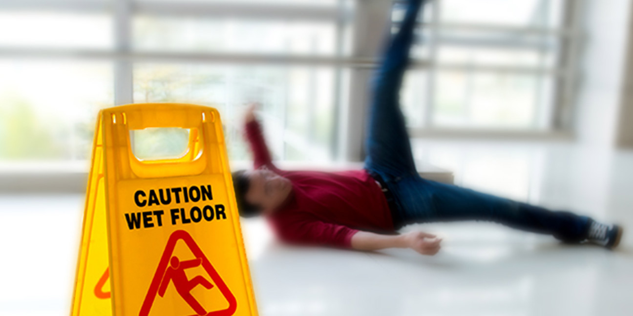Wet Floor Sign and a man in the background appears to have fallen