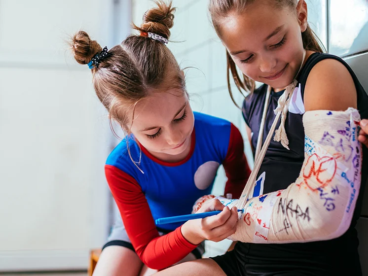 Children writing on a cast.
