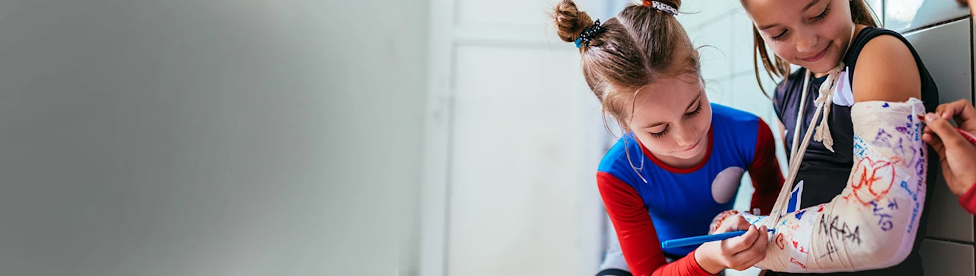Children writing on a cast.