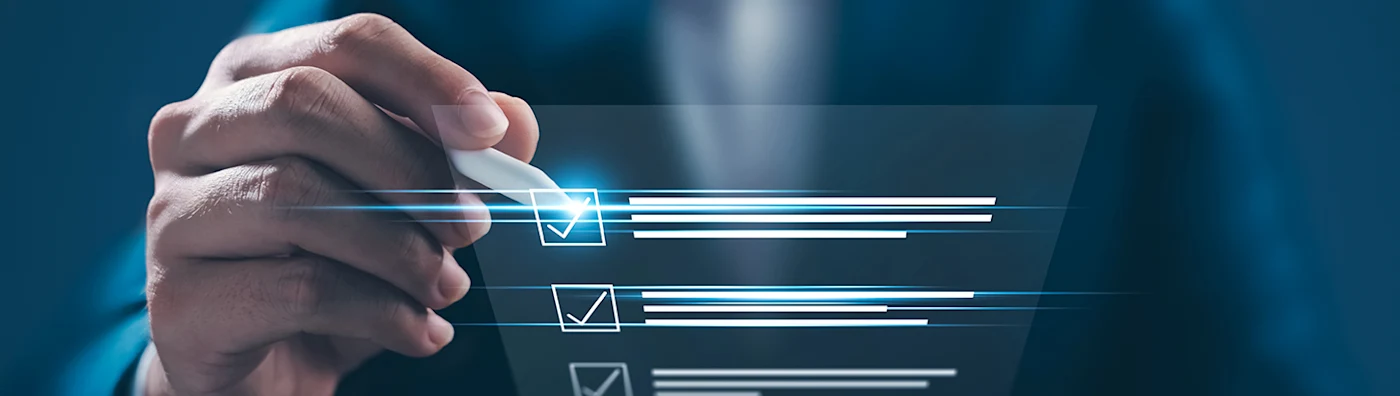 A man holds a translucent checklist, and he is checking the first square with a white pen.