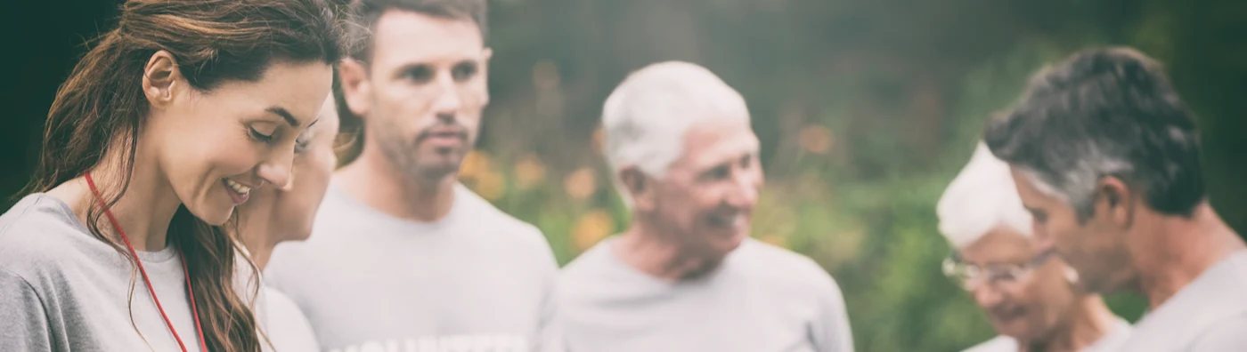 Volunteers sorting through a donation box at a non-profit event.