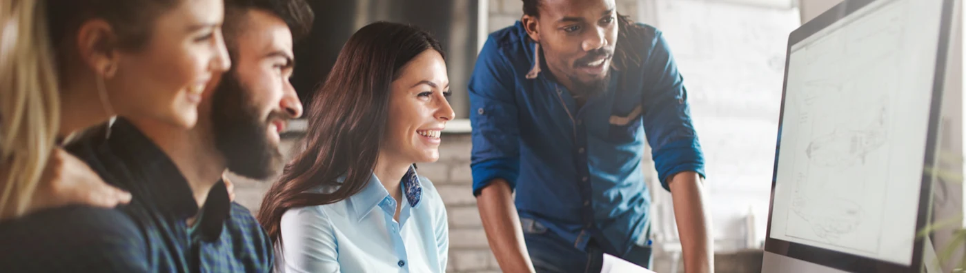 Partial image of a man and woman in an office happily reviewing their tech insurance.