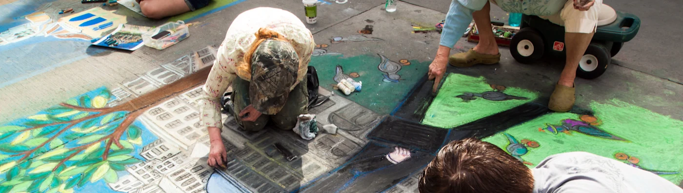 Children drawing with Chalk on side walk.