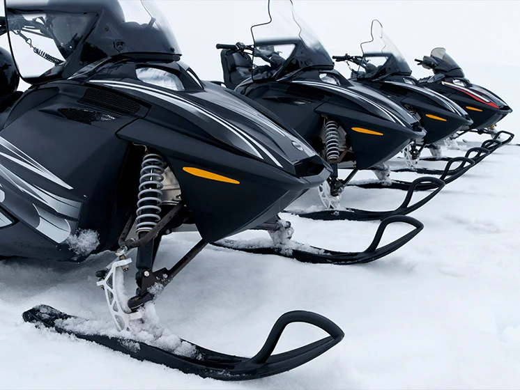 Close up image of 4 snowmobiles. 