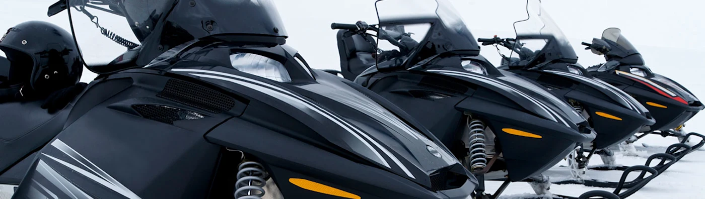 Close up image of 4 snowmobiles. 