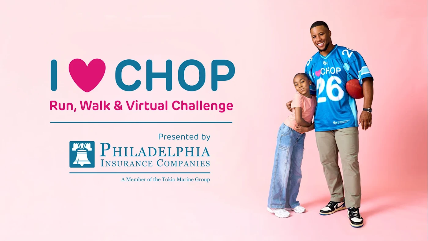 Saquon Barkley and CHOP patient pose next to I HEART CHOP logo.