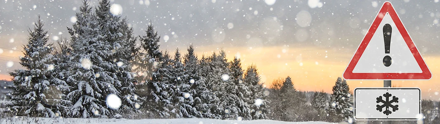 Snowy landscape with a sign warning of winter weather
