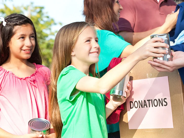 Two children collect donations - note blurred out left half of image