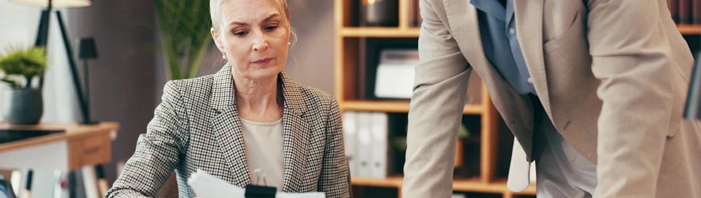 An insurance agent explaining a commercial policy to their client in an office setting. 