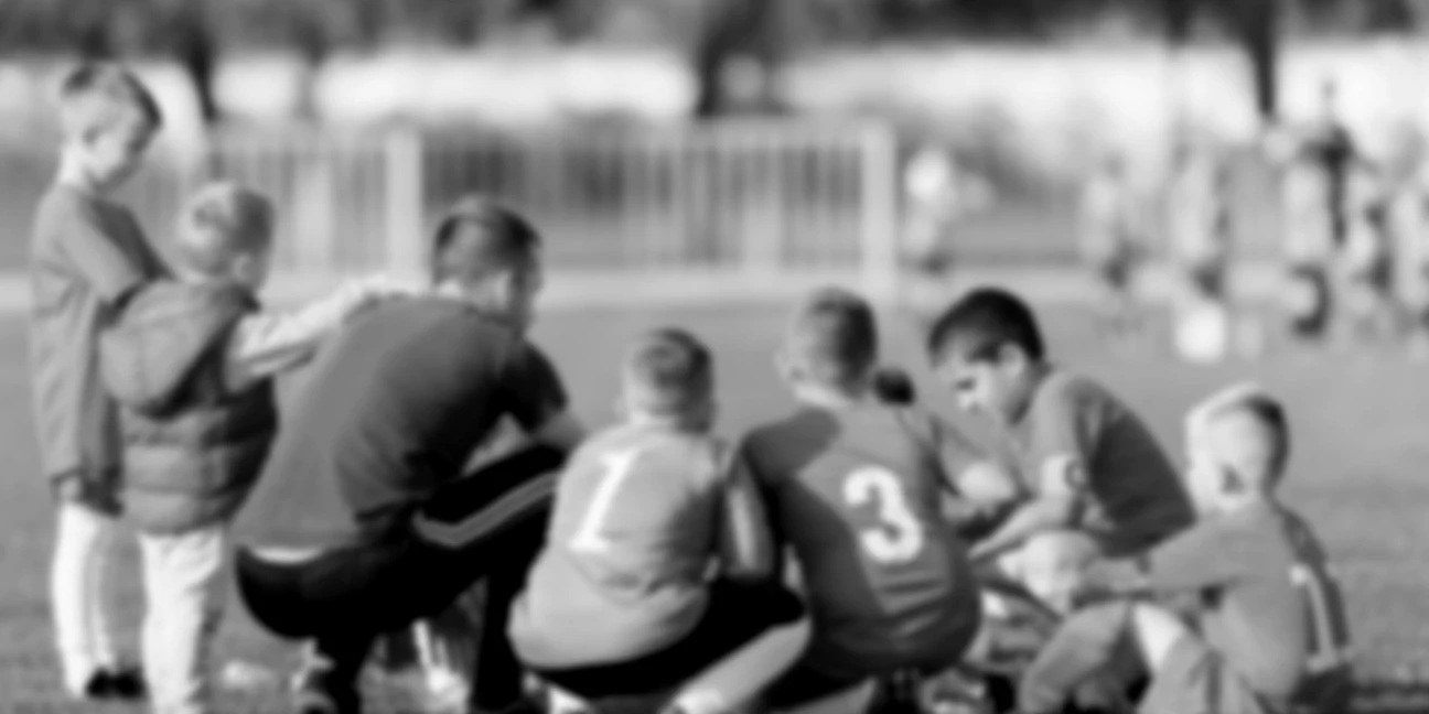 Back image of a coach talking with young players