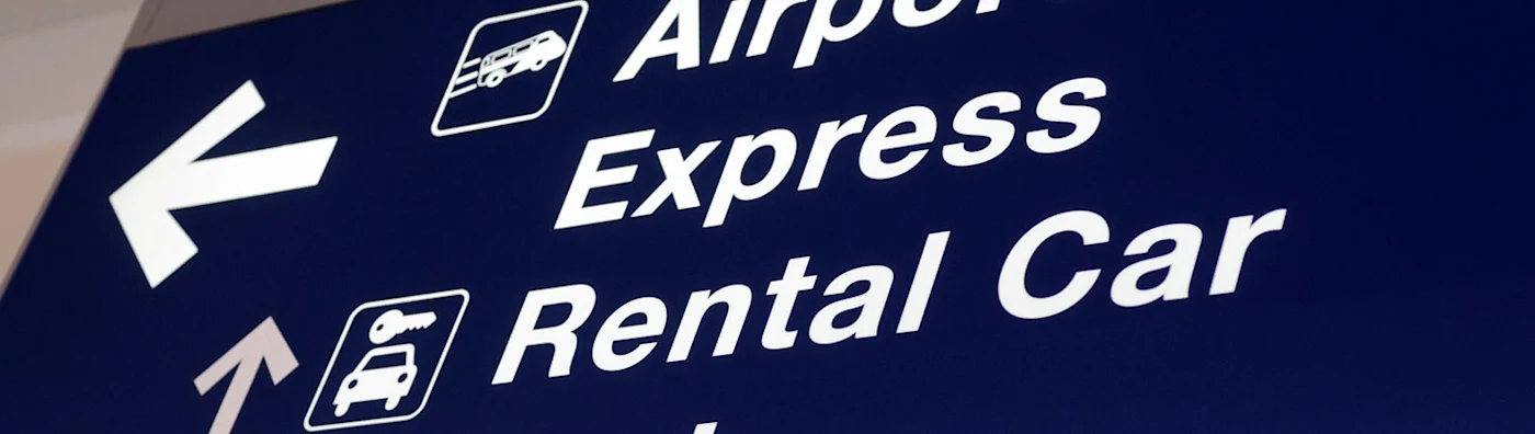 Close up of a directional sign pointing to express and rental car services.