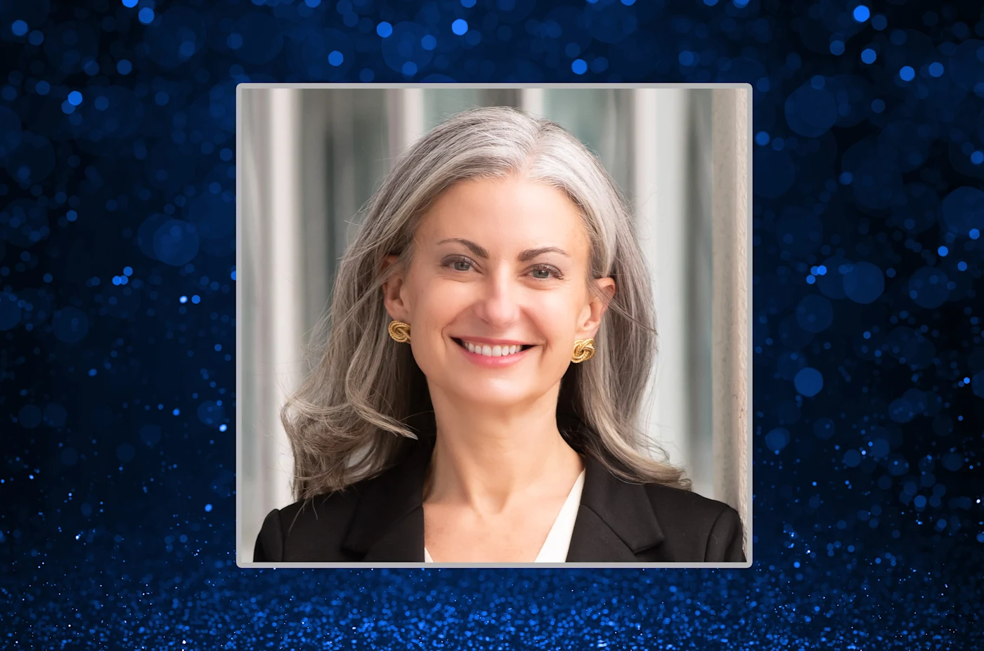 Philadelphia Insurance Companies Senior Vice President & Deputy Chief Underwriting Officer, Kimberly Hamilton, leans against wall smiling.