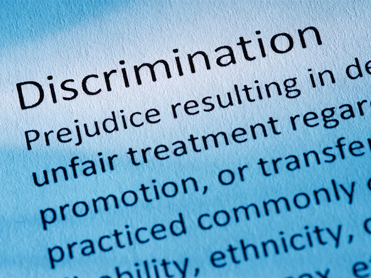 Close up image of printed text highlighting the word “Discrimination” on a document.