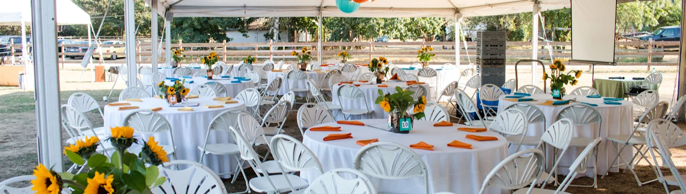 Tables under a tent with multi-color decorations for a private event.