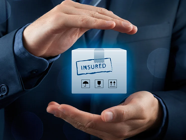 Businessman holds glowing "Insured" cube icon, symbolizing protection and coverage.