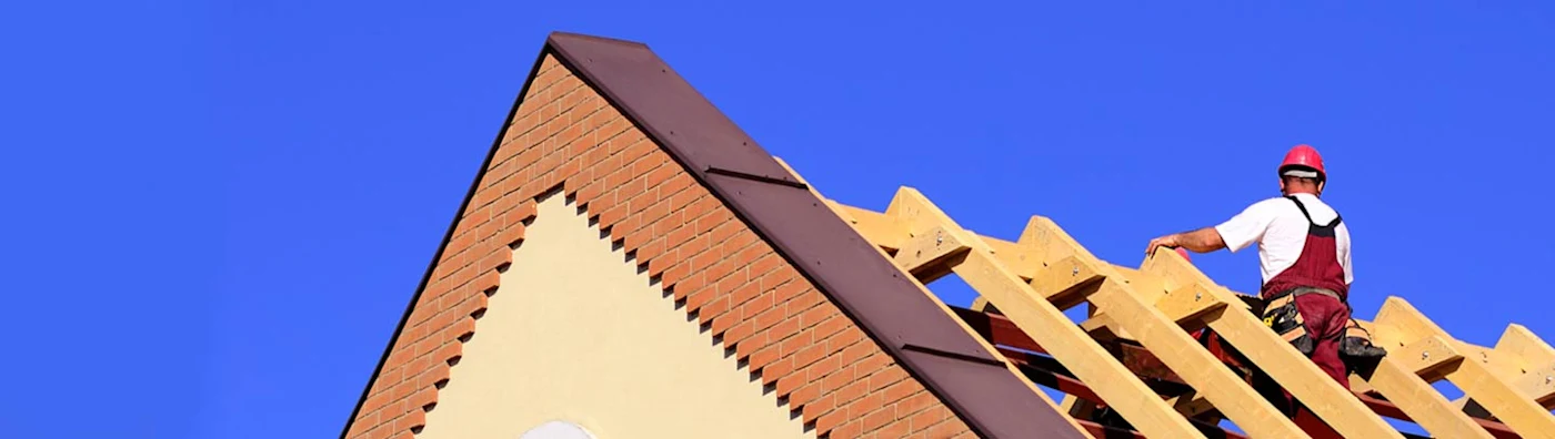 Image of construction worker on a half-built roof