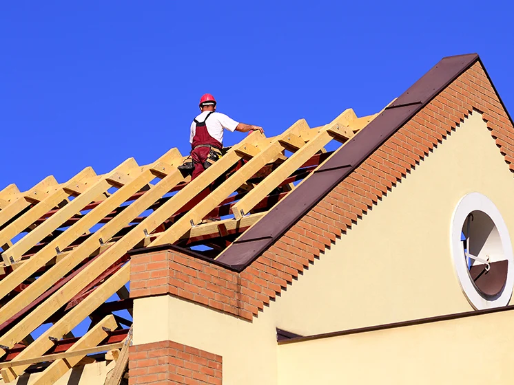 Image of construction worker on a half-built roof