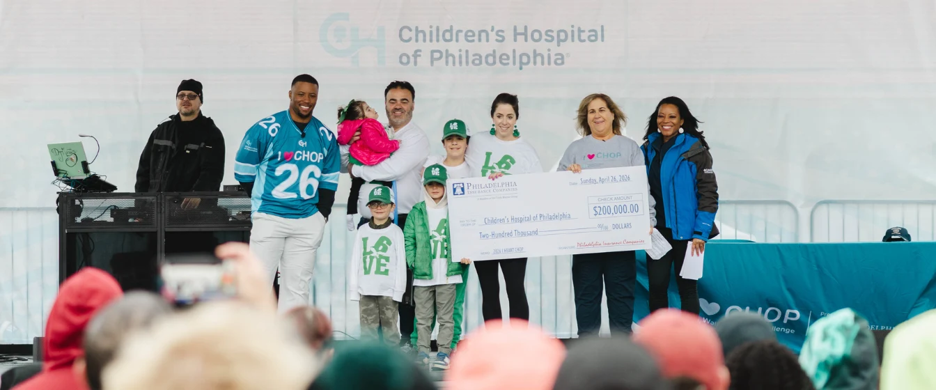 EVP, CFO and Treasurer, Karen A. Gilmer-Pauciello, and Eagles running back, Saquon Barkley, present CHOP with $200,000 donation.