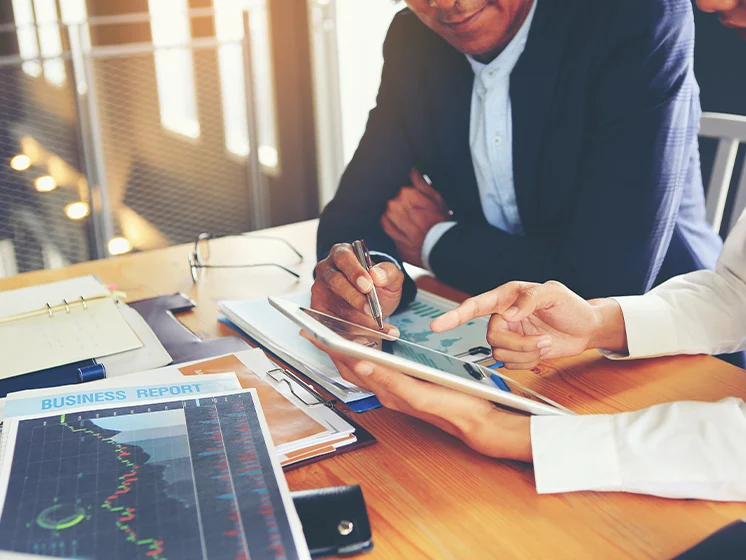 A corporate meeting showing a business plan on a tablet.
