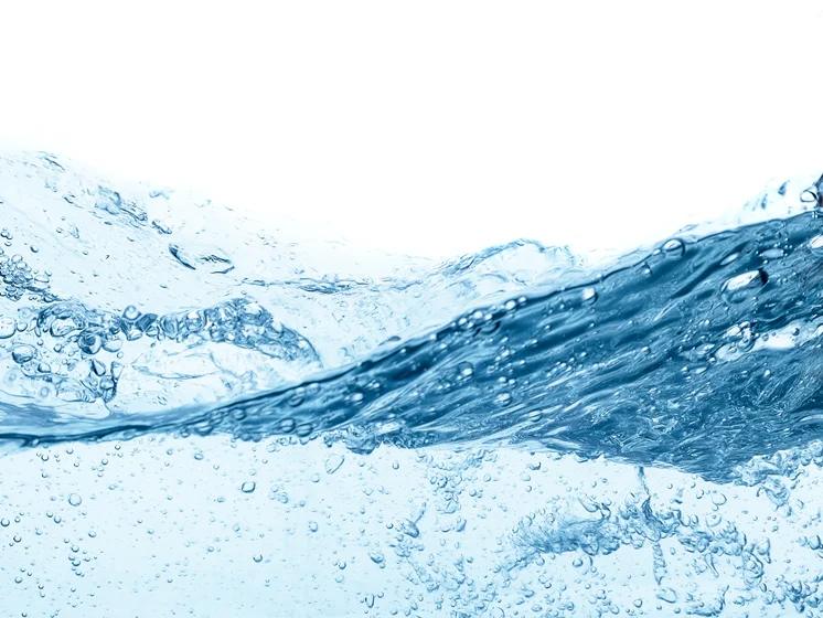 Close up image of clear blue water in motion with bubbles and ripples.