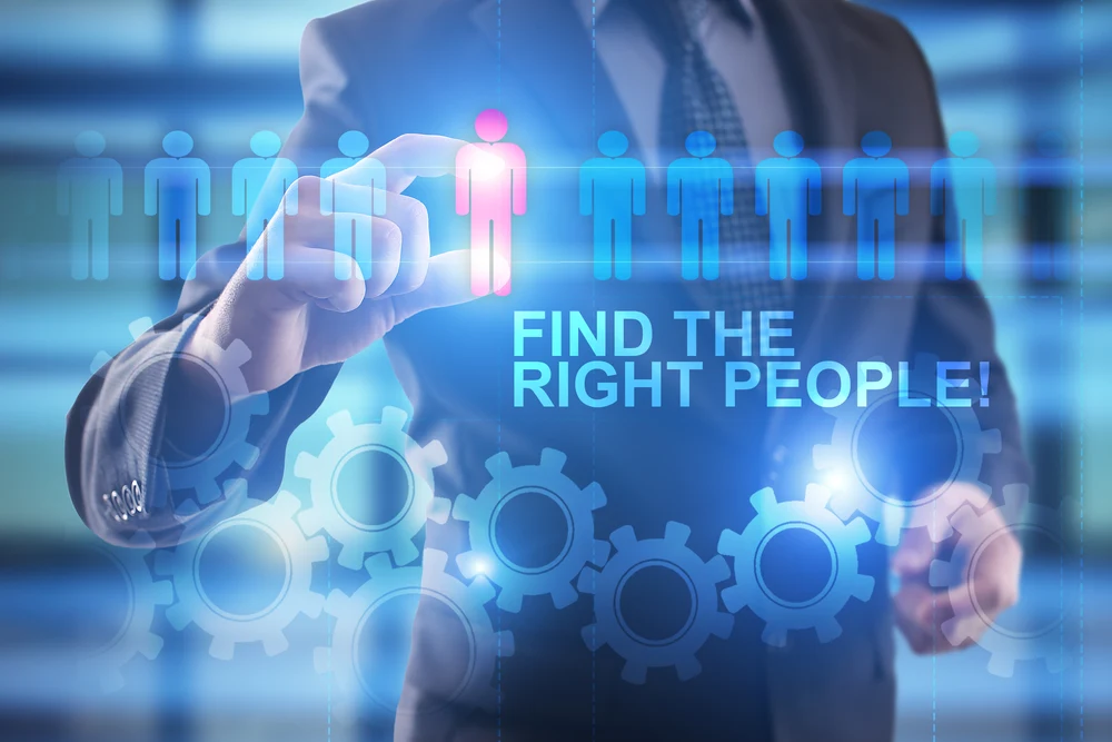 A businessman presses down on a virtual screen and selects "Find the right people."