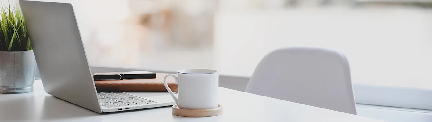 Laptop and coffee cup on a desk