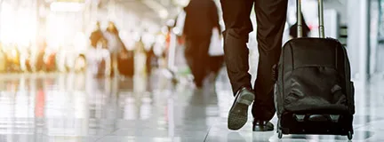 Man walking with rolling suitcase.