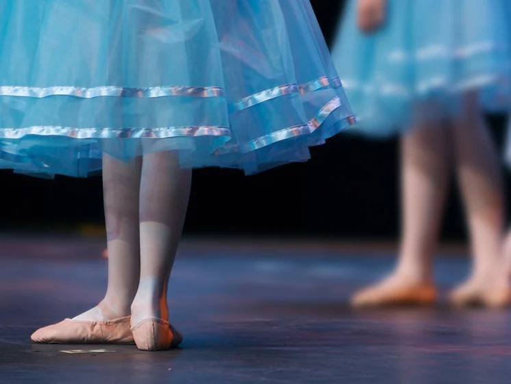 Close up image of ballet dancers' feet on stage.