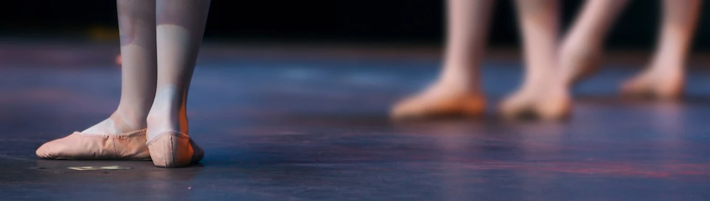 Close up image of ballet dancers' feet on stage.