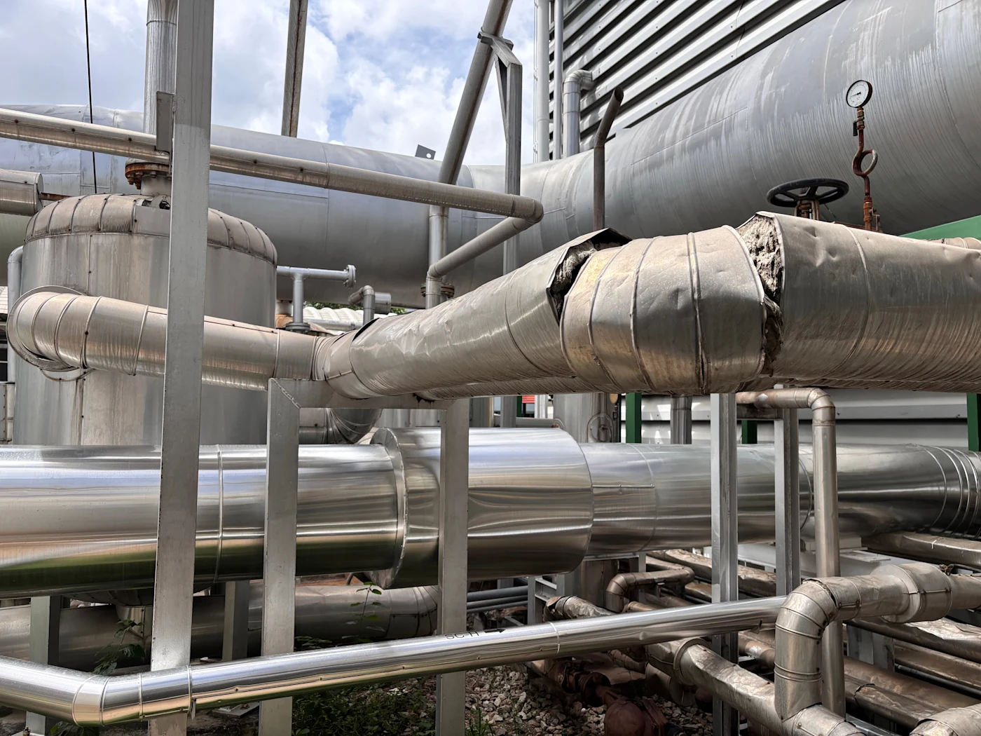 A damaged pipe inside of an aging factory that would benefit from commercial insurance.