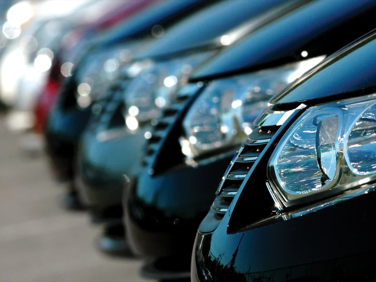 Close up image of cars in a row showing headlights.