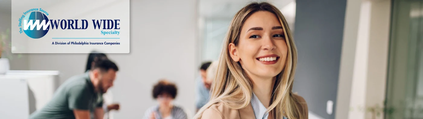Smiling business woman uses a tablet while working on her insurance for staffing firms policy in the office.