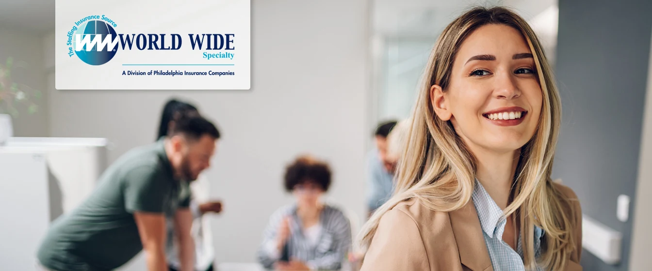 Smiling business woman uses a tablet while working on her insurance for staffing firms policy in the office. 