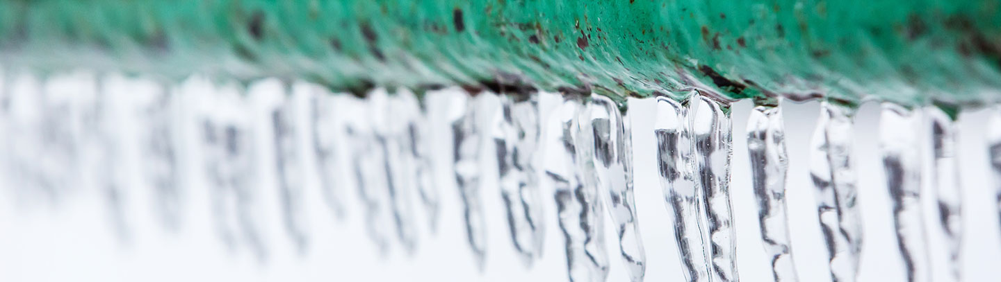 close up of ice on a building's pipe