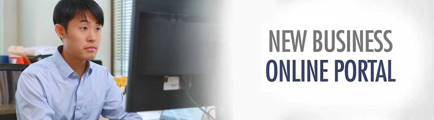 Man with a blue shirt sitting in front of a computer monitor working.