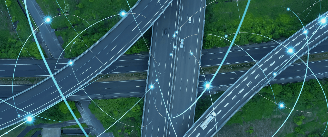 Cars and trucks driving on a highway interchange while transmitting data.