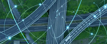 Cars and trucks driving on a highway interchange while transmitting data.