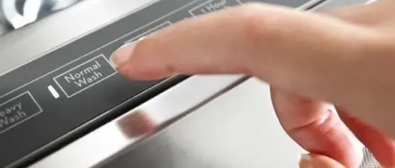 Hand choosing normal wash cycle on dishwasher