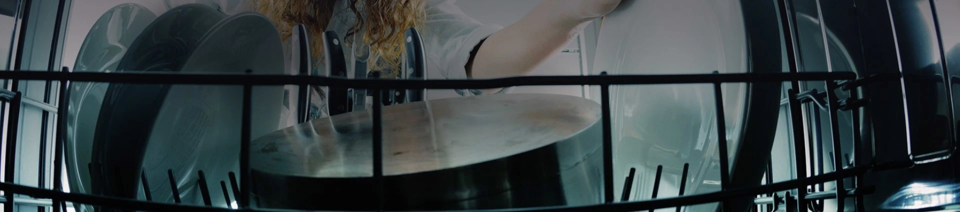 Woman loading dirty dishes into dishwasher