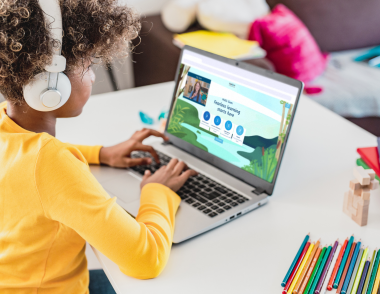 A young child sits at a desk in front of a laptop where they are using Explore Learning smart digital learning tool.