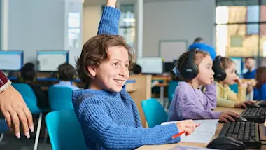 A child raising their hand to ask a question during their Explore Learning maths and English tuition session