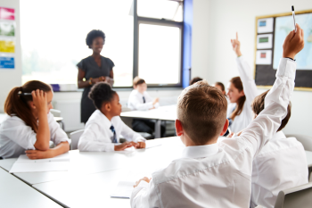 a group of children around a table in a school classroom.