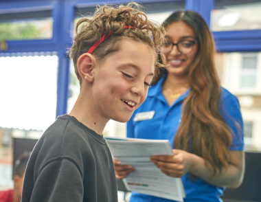 A close up on the face of a teenage child with a tutor.