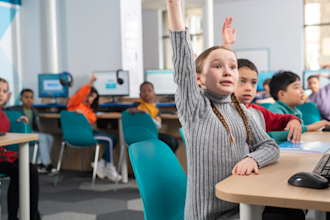 Girl raising her hand to answer a question in an Explore Learning tuition centre