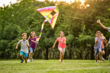 Children playing with a kite in a field