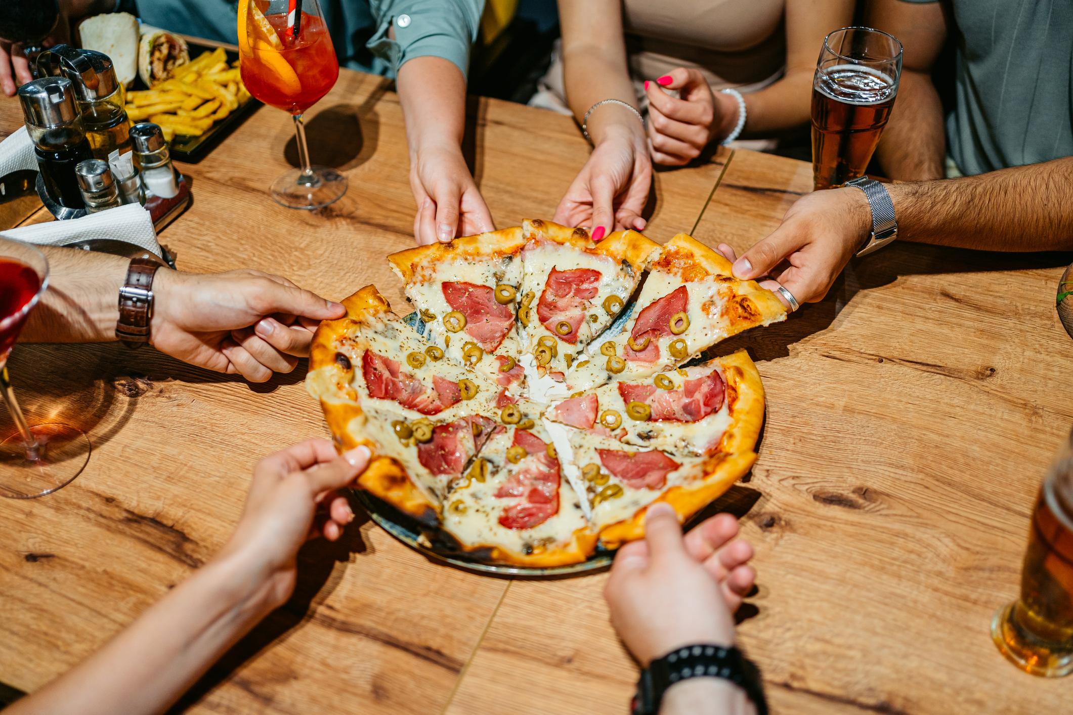 People sharing a pizza in a restaurant