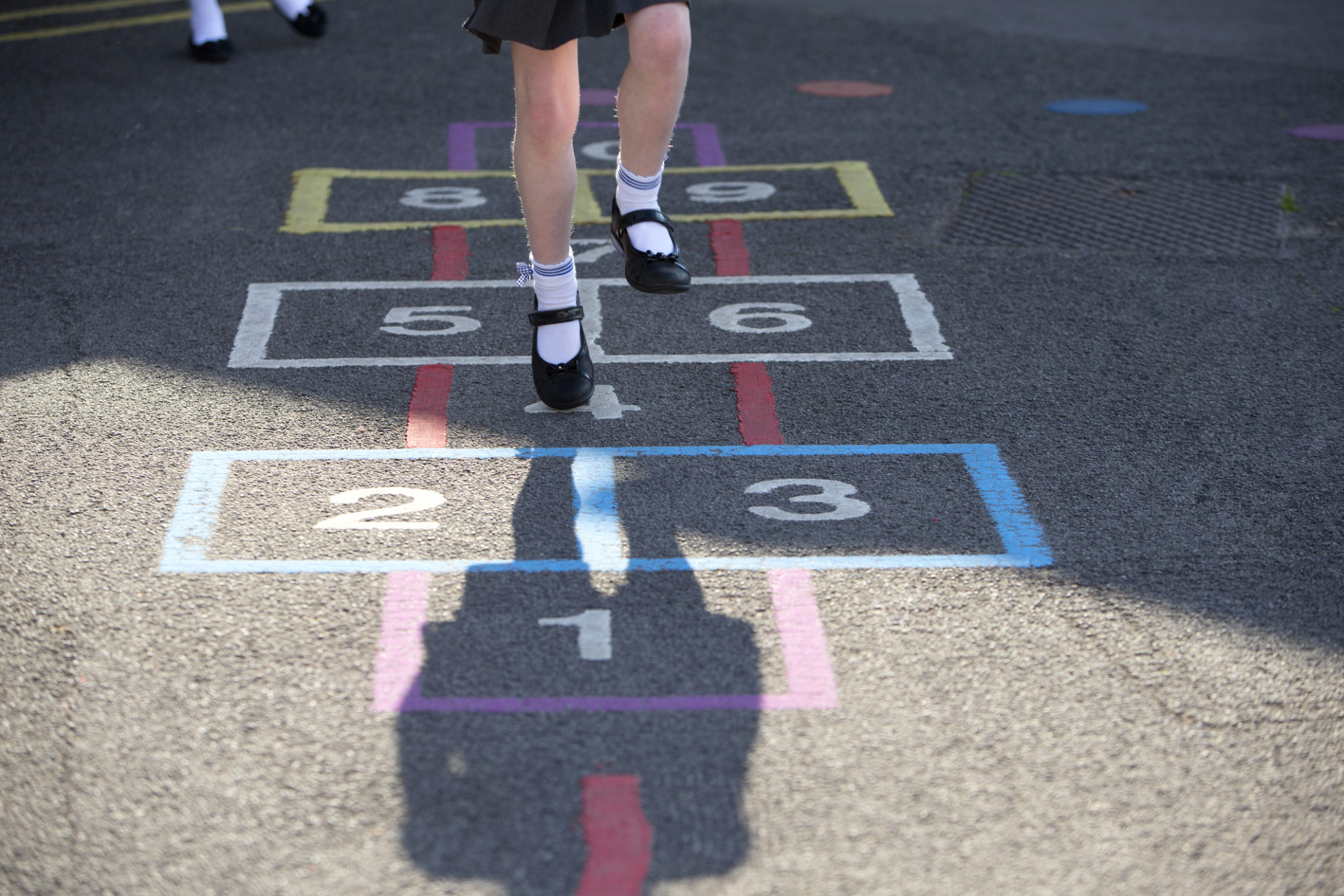 Child playing hopskotch in the playground